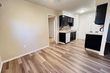 a living room and kitchen with wood flooring and black cabinets at Hunter Ridge Apartments, Cincinnati, Ohio, 45244
